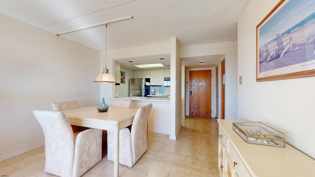 dining room with a textured ceiling and light tile patterned flooring