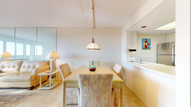 dining space featuring sink and a textured ceiling