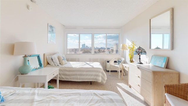 bedroom with a textured ceiling and light colored carpet