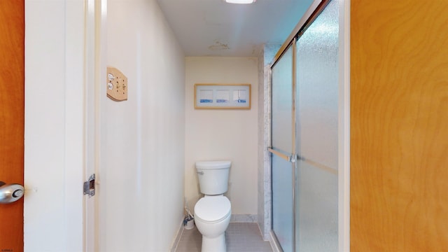 bathroom with tile patterned floors, toilet, and walk in shower