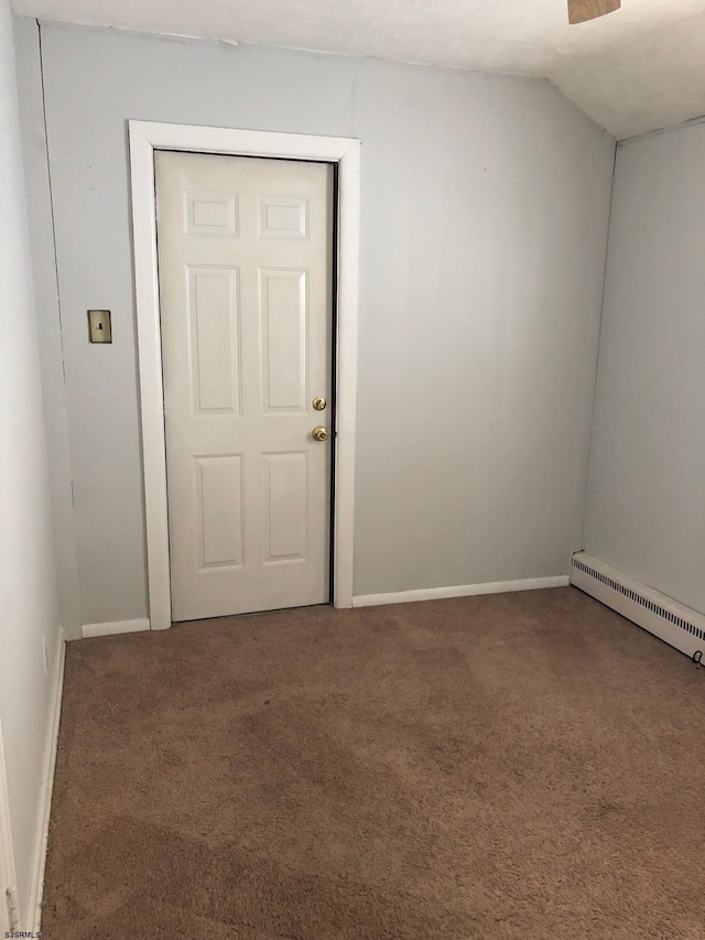 spare room with lofted ceiling, a baseboard radiator, and carpet floors