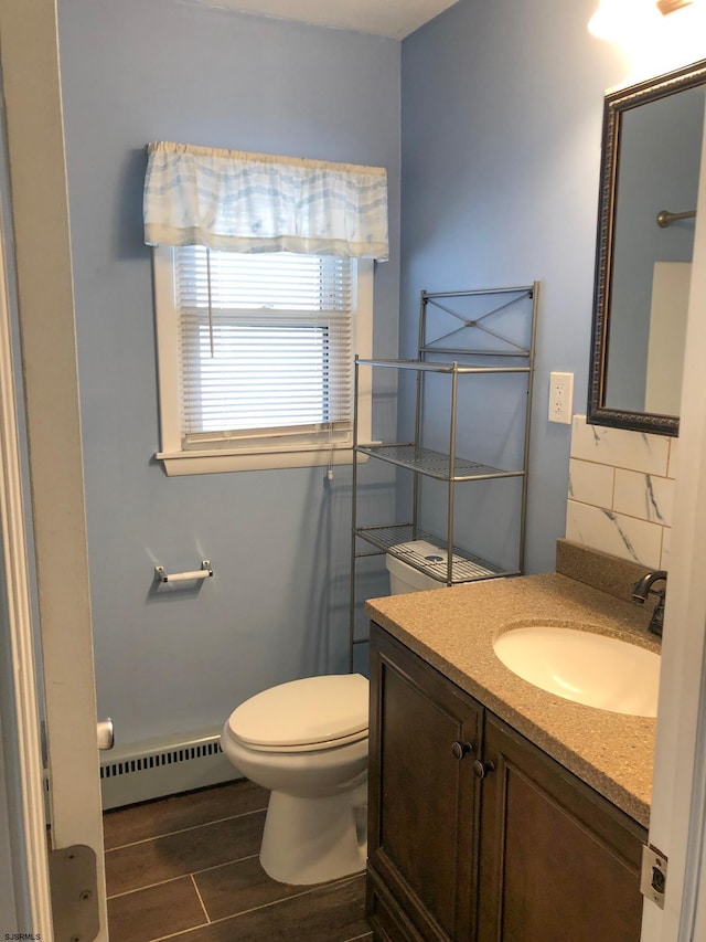 bathroom with toilet, a baseboard heating unit, and vanity