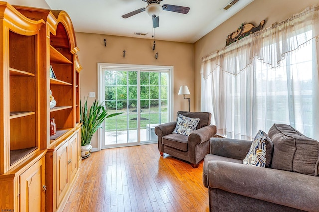 living room with light hardwood / wood-style floors and ceiling fan