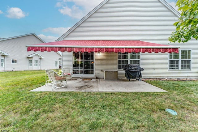 rear view of property featuring a yard and a patio area