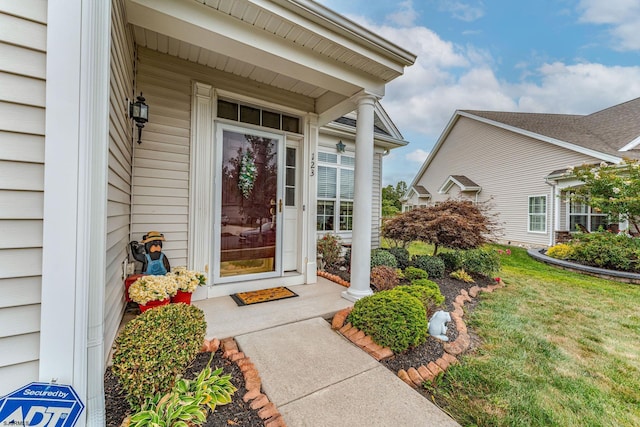 view of exterior entry with a lawn