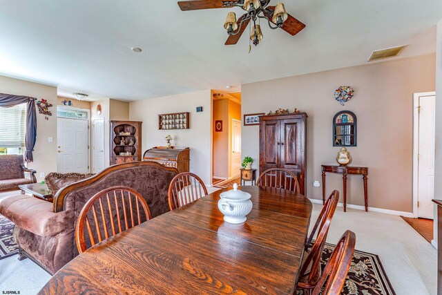 carpeted dining area featuring ceiling fan