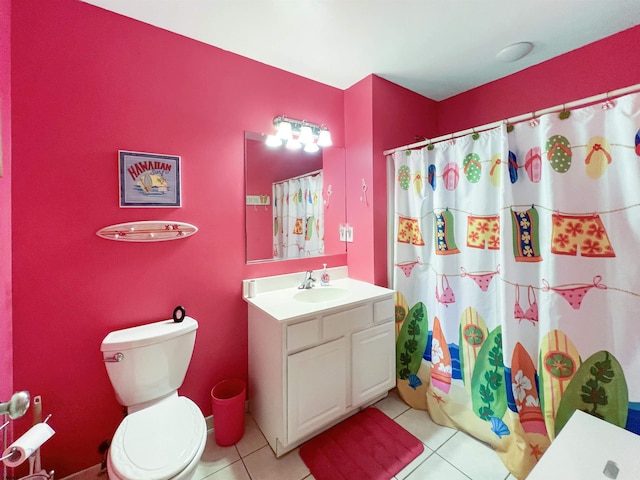 bathroom with toilet, vanity, and tile patterned floors