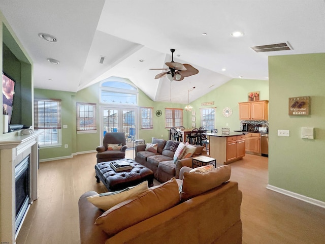 living room with ceiling fan, lofted ceiling, and a wealth of natural light