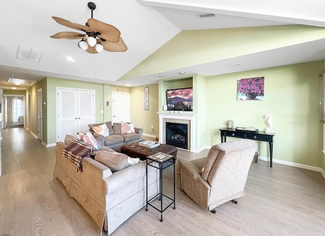 living room with light hardwood / wood-style floors, vaulted ceiling, and ceiling fan