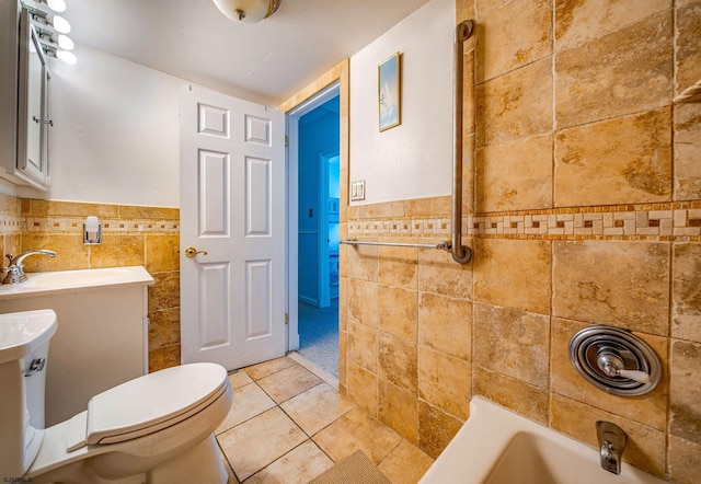 bathroom with tile patterned flooring, vanity, toilet, and tile walls