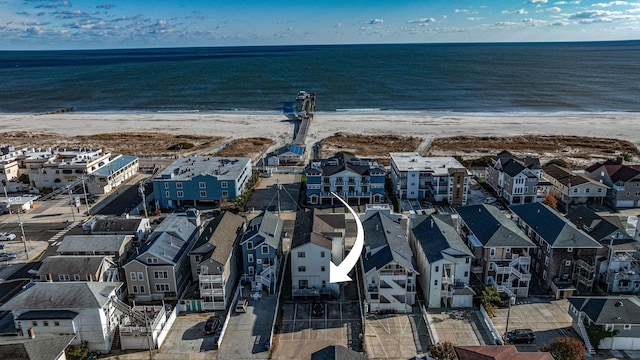 drone / aerial view with a water view and a beach view