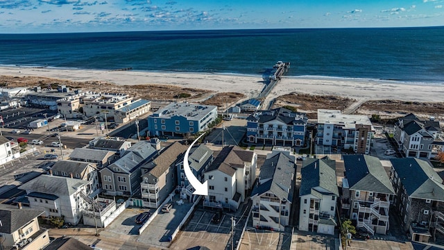 birds eye view of property with a water view and a beach view