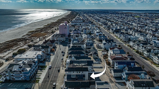 birds eye view of property featuring a water view and a beach view