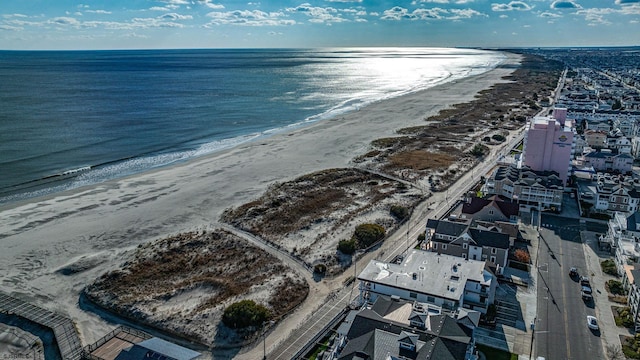 birds eye view of property featuring a water view and a beach view