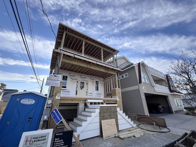 view of front of home featuring a garage, concrete driveway, and stairway