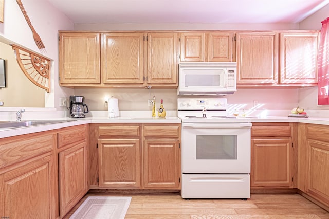 kitchen with light hardwood / wood-style floors, white appliances, and sink