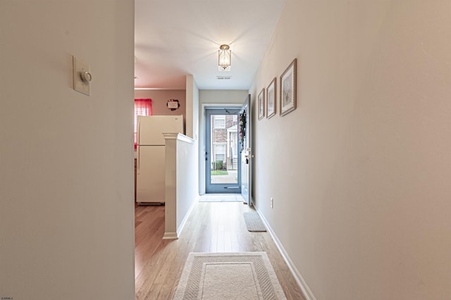 hallway with light hardwood / wood-style floors