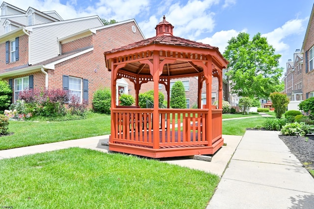 view of community featuring a gazebo, a wooden deck, and a lawn