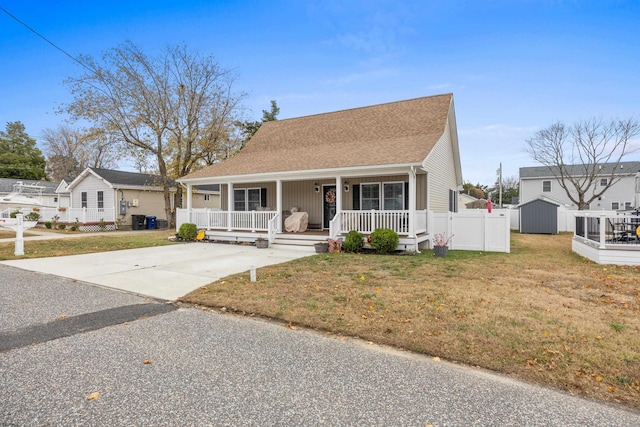 view of front of house with a front yard, a porch, central AC, and a storage unit