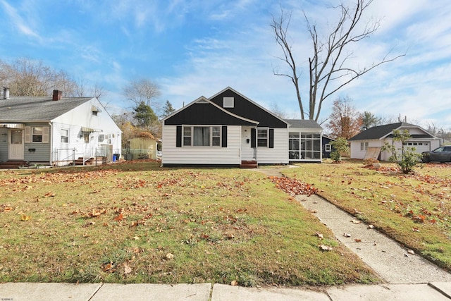 view of front facade with a sunroom and a front lawn