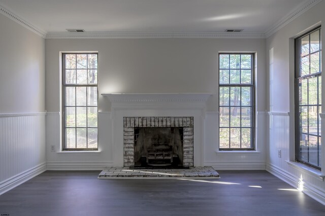 unfurnished living room featuring plenty of natural light, dark wood-type flooring, and ornamental molding