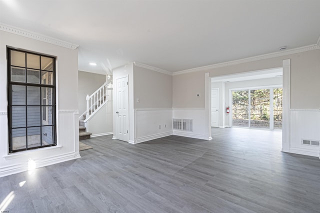 unfurnished living room featuring hardwood / wood-style floors and crown molding