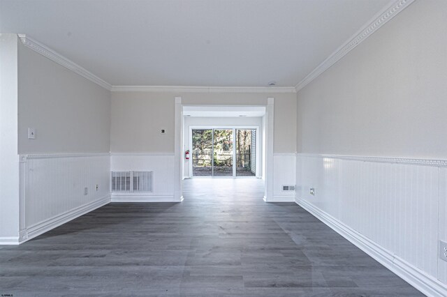 empty room with dark hardwood / wood-style flooring and ornamental molding