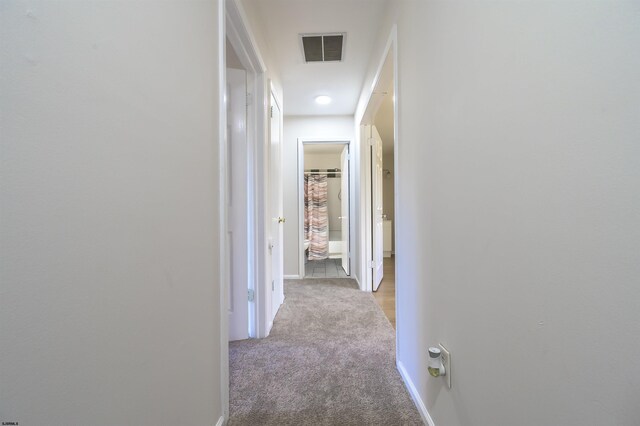 corridor featuring light colored carpet