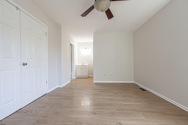 unfurnished bedroom with ceiling fan, connected bathroom, and light hardwood / wood-style flooring