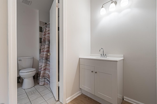 bathroom featuring tile patterned flooring, vanity, a shower with shower curtain, and toilet