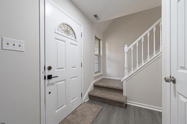 foyer with vaulted ceiling and dark wood-type flooring