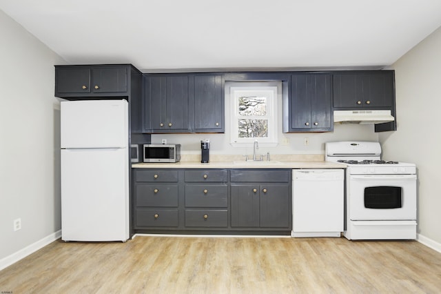 kitchen featuring light wood-type flooring, white appliances, and sink