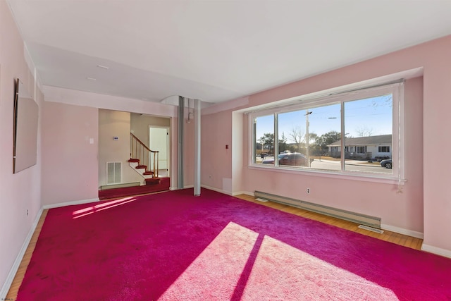 unfurnished room featuring wood-type flooring and baseboard heating