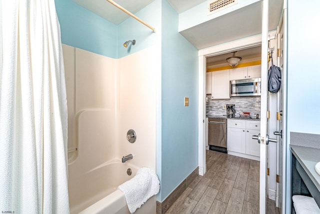 bathroom featuring tasteful backsplash, shower / tub combo with curtain, vanity, and hardwood / wood-style flooring