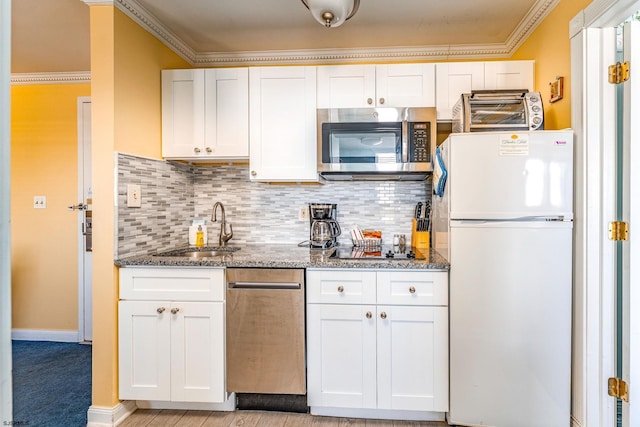 kitchen featuring white refrigerator, white cabinetry, and ornamental molding