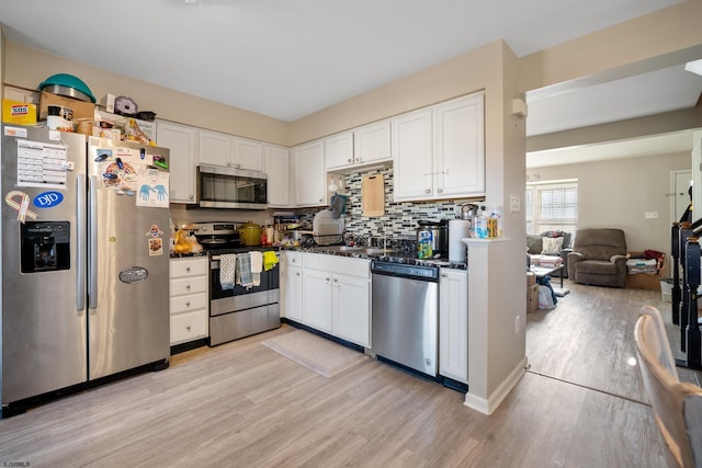 kitchen with white cabinets, stainless steel appliances, light hardwood / wood-style floors, and sink