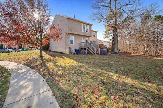 rear view of property featuring a wooden deck and a yard