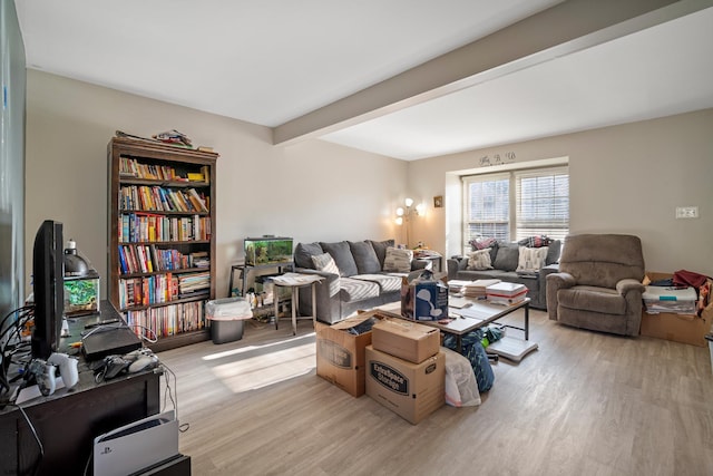 living room with beam ceiling and light hardwood / wood-style flooring