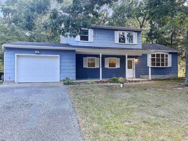 front of property with a porch, a garage, and a front yard