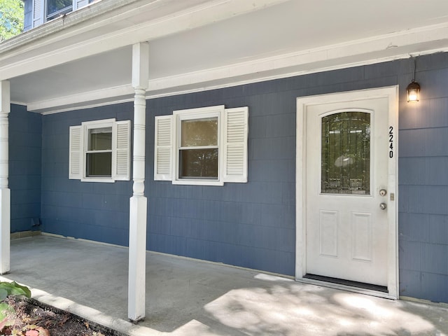 view of exterior entry featuring covered porch