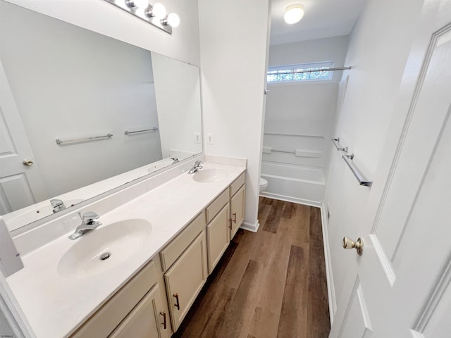 full bathroom featuring toilet, vanity,  shower combination, and hardwood / wood-style flooring