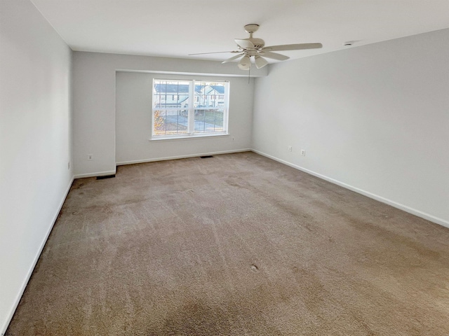 carpeted spare room with ceiling fan