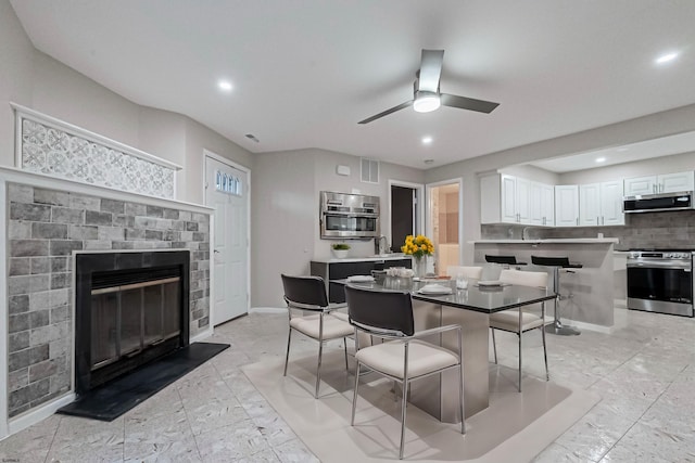 dining area featuring a fireplace and ceiling fan