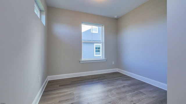 unfurnished room with dark wood-type flooring