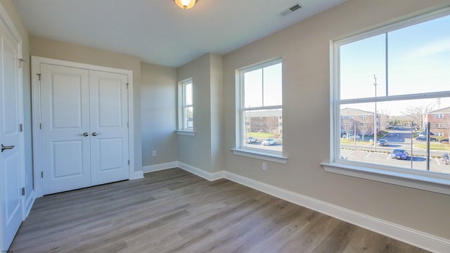 unfurnished bedroom featuring light wood-type flooring and a closet