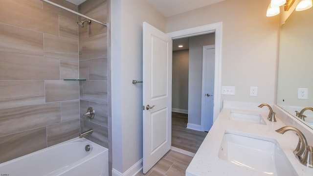 bathroom featuring tiled shower / bath combo and vanity