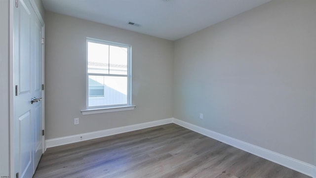 unfurnished room with hardwood / wood-style flooring