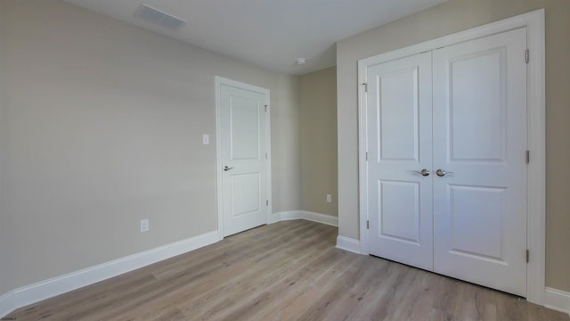 unfurnished bedroom featuring a closet and light wood-type flooring