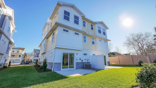 rear view of house featuring a yard, central AC unit, and a patio area