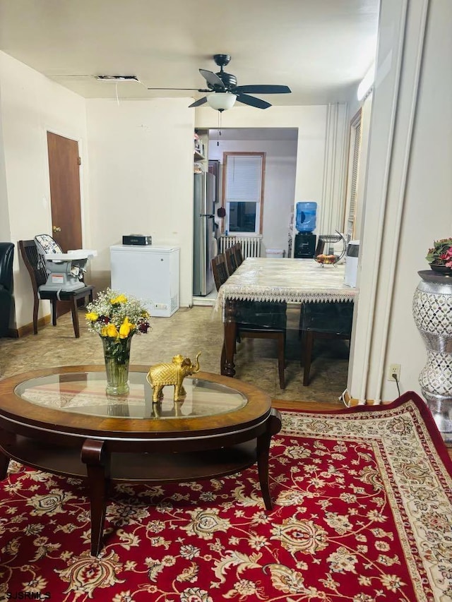 living area with ceiling fan and radiator heating unit